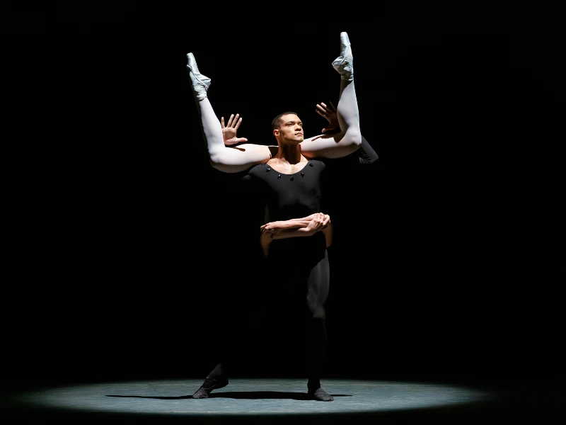 NYCB's Preston Chamblee dressed in black with Emily Kikta's legs in the air in George Balanchine’s Episodes. Photo by Erin Baiano