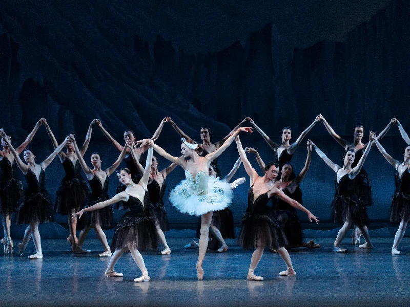 New York City Ballet's Miriam Miller in a white tutu with the Company in black tutus in George Balanchine’s Swan Lake.