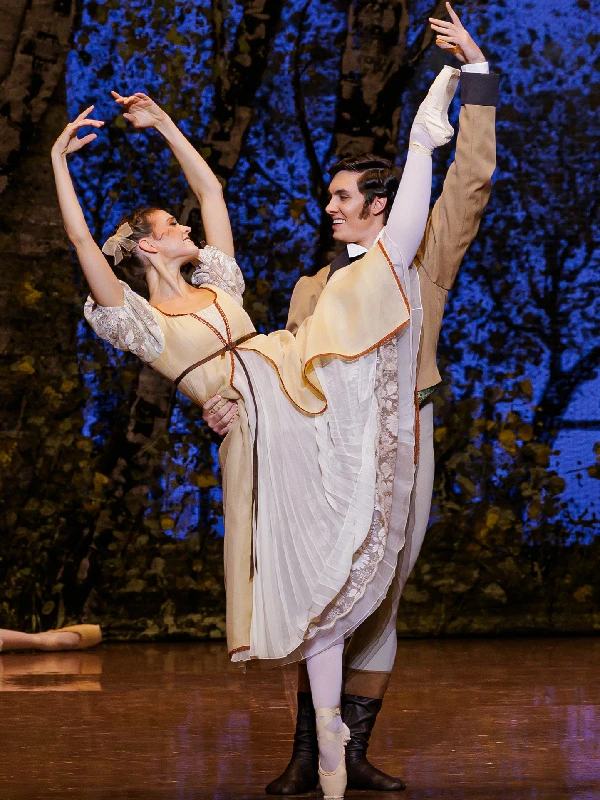 The Stuttgart Ballet's Mackenzie Brown and Gabriel Figueredo in John Cranko's Onegin as Olga wearing a long white dress and Lensky wearing a tan-colored suit.