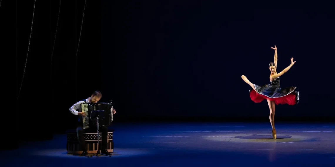 Dutch National Ballet Program A Review 2025 in NYC featuring Vincent Van Amsterdam on the accordion accompanying Lore Zonderman in a black, white and red dress.