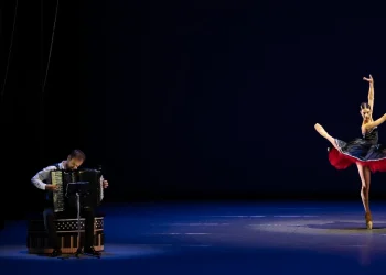 Dutch National Ballet Program A Review 2025 in NYC featuring Vincent Van Amsterdam on the accordion accompanying Lore Zonderman in a black, white and red dress.
